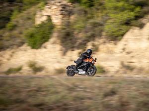 Ein Mensch fährt auf einer Harley Davidson, der Hintergrund ist unscharf gehalten um das Tempo zu simulieren