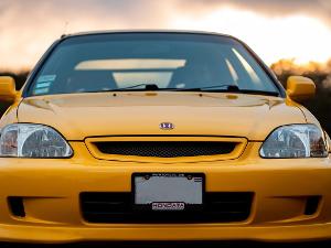 Ein gelber Honda steht direkt vor der Kamera, man sieht das Hondazeichen auf der Motorhaube