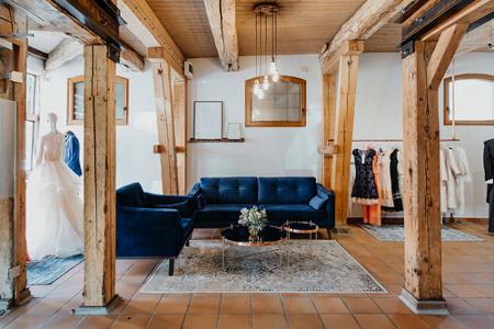 Blaue Sofas, Holzbalken und Brautkleider im Geschäft