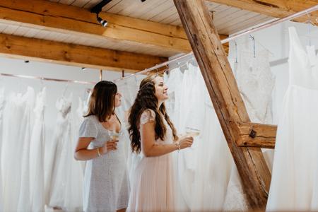 Frauen schauen sich Brautkleider an