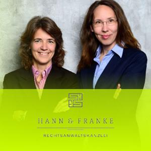 Bild von den Rechtsanwältinnen Frau Hann und Frau Franke mit einem gelben Firmenlogo.
