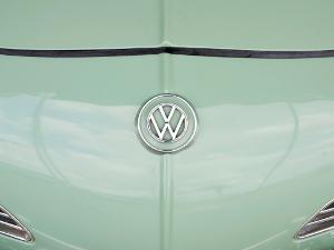 Das VW Zeichen auf der Motorhaube eines mintgrünen Autos