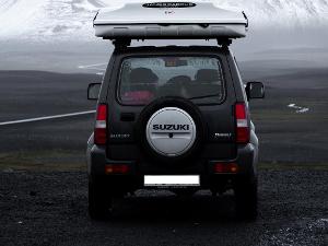 Ein Geländewagen von hinten fotografiert fährt durch eine flache Landschaft