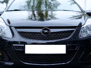 Front eines schwarzen Autos, mit dem Opelzeichen über dem Kühler