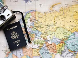 Eine Fotokamera und ein Reisepass auf einer Weltkarte