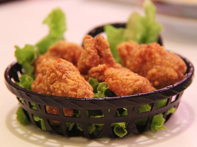 frittierte Hähnchenschenkel auf einem Salatblatt in einem Körbchen