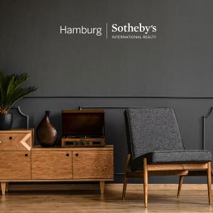 Holzsideboard und ein Stuhl vor einer grauen Wand