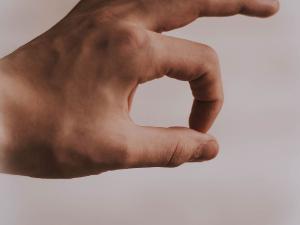 Hand einer Person formt mit den Fingern ein ok-Zeichen.