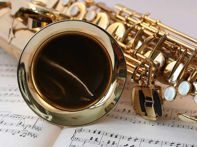 Saxophon liegt auf einem Notenblatt