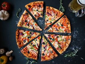 Eine geschnittene Pizza mit Oliven und Paprika