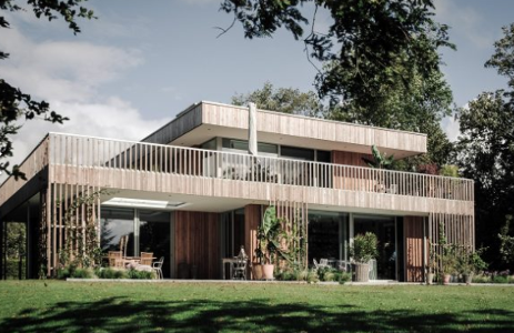 Einfamilienhaus mit Holzverschalung und großem Balkon im Grünen