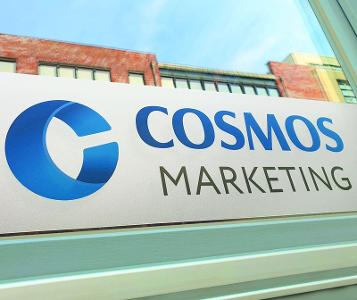 Cosmos Marketing Logo auf einer Folie die an einer Scheibe angebracht ist