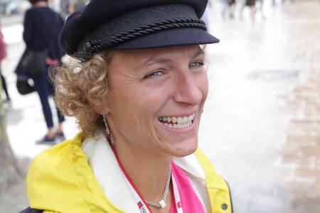 Auf diesem Bild lächelt die Gästeführerin Hamburg Guide Sarah aus dem Schrägprofil in die Kamera, gekleidet mit gelbem Friesennerz und einer typischen Hamburger Mütze, dem Reepschläger – ähnlich dem Elbsegler