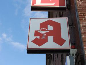 Ein Schild mit einem roten A hängt an einer Häuserwand