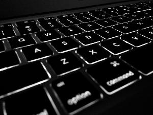 Eine schwarze Laptoptastatur mit weißen Buchstaben und Zeichen darauf.