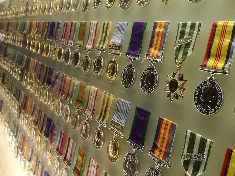 Verschiedenste Medaillen hängen nebeneinander in einem Schaukasten an der Wand