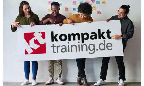 Vier Menschen halten das Logo von Kompakttraining GmbH & Co. KG in der Hand