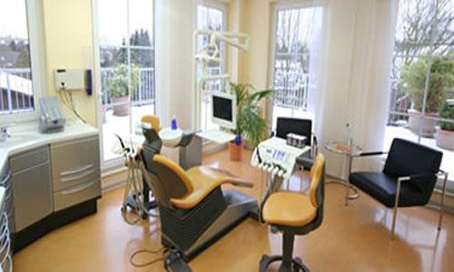 Behandlungszimmer der Zahnarztpraxis Bokel mit Untersuchungsstuhl und Blick ins Grüne