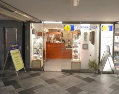 Außenansicht des Ladengeschäftes von LB Uhrmacher Hamburg mit gelben Schild vor der Tür