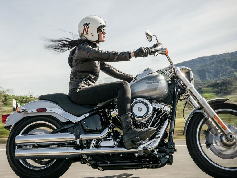 Frau mit schwarzem Lederanzug auf einer Harley-Davidson