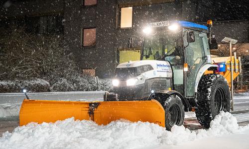 Einsatzfahrzeug Kubota L-Schlepper im Nachteinsatz bei Schneeräumen