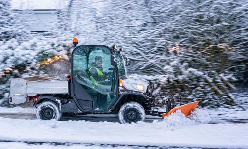 Einsatzfahrzeug räumt den Gehweg frei von Schnee.