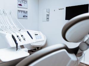 Behandlungsraum bei einem Zahnarzt mit Behandlungsstuhl und medizinischen Geräten