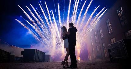 Mann und Frau halten sich in den Armen und schauen sich ein Feuerwerk an