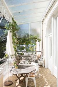 Balkon mit Glasdach und weißem Gestühl