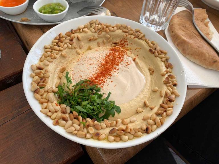 Hummus, ein arabischer Dip oder Aufstrich, aus gekochten Kichererbsen mit Tahini (einer Paste aus Sesamsamen), Zitronensaft, Knoblauch und Salz vermischt
