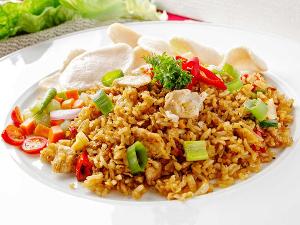 Gebratener Reis mit Hühnchen und Gemüse auf einem weißen Teller