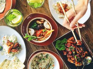 Draufansicht, Schälchen und Teller mit verschiedenen asiatischen Gerichten, Reis mit Gemüse, Fleisch in Soße und Suppe