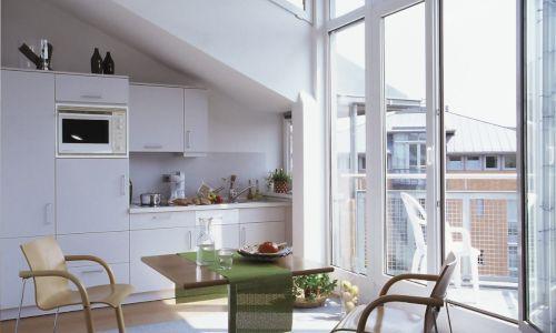 Küchenzeile mit Esstisch und Stühlen vor Balkon