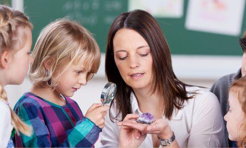 Erzieherin und Kinder untersuchen einen Amethyst