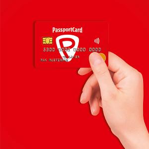 Eine Hand hält die PassportCard in den Fingern, die Karte ist rot und der Hintergrund auch