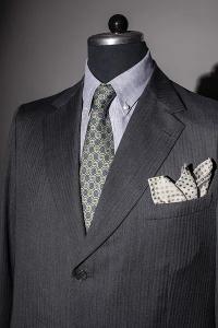 Ein dunkler Anzug, mit Einstecktuch und Krawatte auf einer Modepuppe