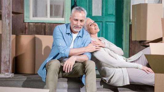 Ein Mann sitzt auf Treppenstufen vor einer grünen Tür und eine Frau lehnt sich an seine Schulter