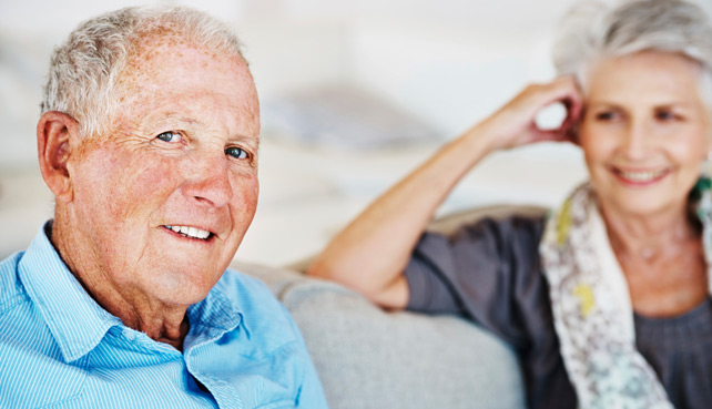 Ein älterer Mann und eine ältere Frau sitzen auf einem Sofa