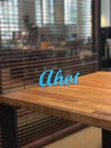 Ein blauer Ahoi Schriftzug steht auf einem Holztisch