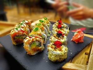 Drei verschiedene Sorten Sushi auf einer schwarzen Schiefertafel