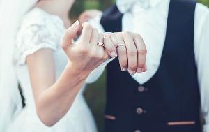 Mann und Frau halten sich die Hand mit jeweils einem Ring am Ringfinger