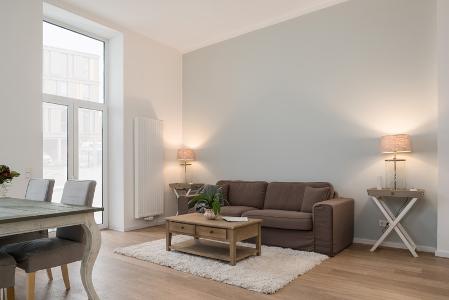 Ein helles Wohnzimmer mit Esstisch, Sofa und Couchtisch