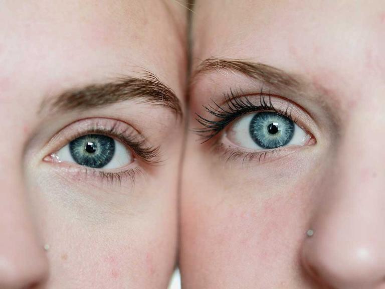 Zwei Frauen stehen Kopf an Kopf nebeneinander mit Blick auf das Augenpaar.