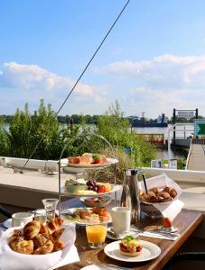 Frühstücksbuffet auf einem Holztisch, im Hintergrund die Elbe
