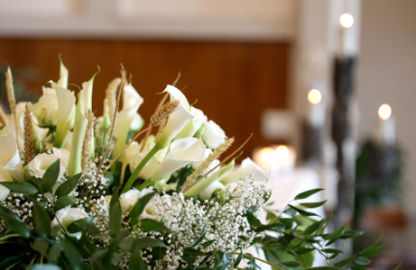 Blumen und im Hintergrund ein Saal für die Trauerfeier