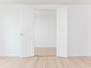 Eine weiße Doppelflügeltür und heller Holzfußboden