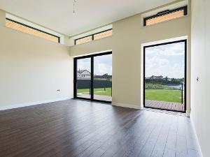 Ein leerer Raum in einer Immobilie mit zwei bodentiefen Fenster zum Garten
