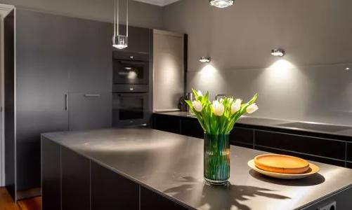 Eine dunkelgraue Küchenzeile mit einer Vase mit Tulpen darauf