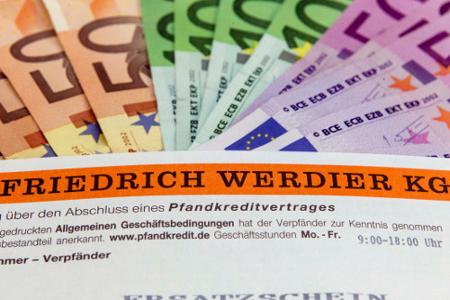 Gefächerte Geldscheine und darunter ein orangefarbener Banner mit der Aufschrift Friedrich Werdier KG