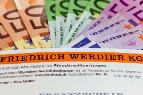 Gefächerte Geldscheine und darunter ein orangefarbener Banner mit der Aufschrift Friedrich Werdier KG